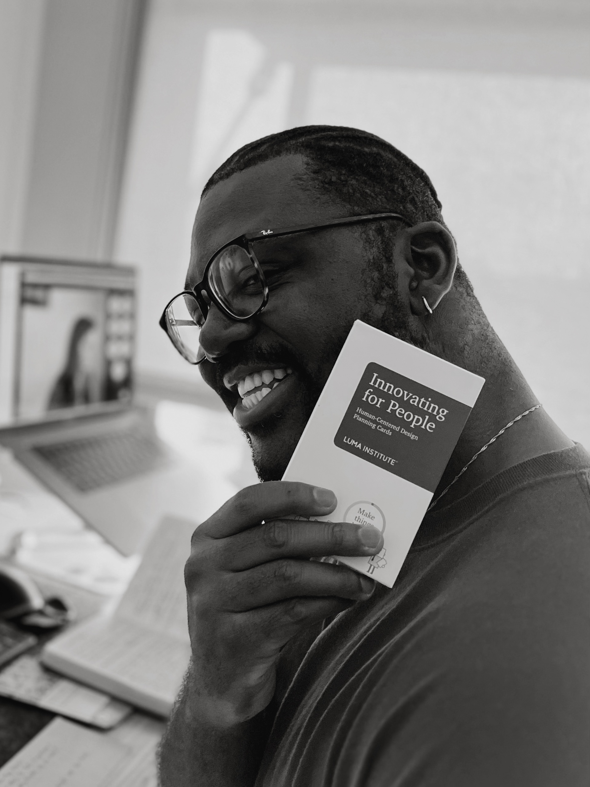 A picture of Pompidou holding a pack of LUMA Institute cards.